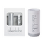 To the left, a white box showcases the Überlube refillable case and a 15ml insert, while to the right, a white cylindrical tube of 55ml Überlube lubricant stands upright. These elegant packaging options demonstrate WorldCondoms' commitment to offering discreet and high-quality personal care products.