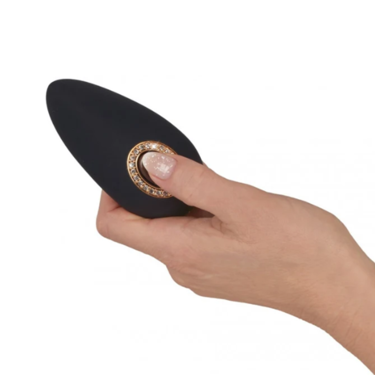 Close-up of a hand with manicured nails holding the black Cleopatra clitoral massager and pressing the central rhinestone-embellished power button.