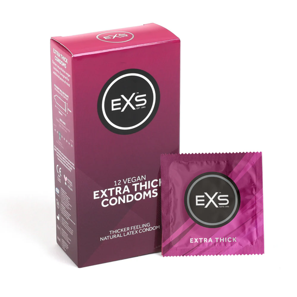 Studio product shot showing the magenta box of EXS 12 Vegan Extra Thick Condoms standing next to a single sealed magenta foil wrapper against a plain white background.
