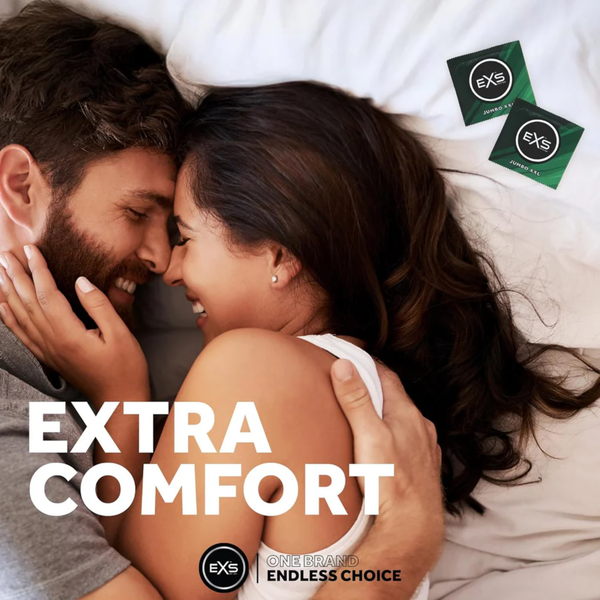 Lifestyle photograph of a smiling couple embracing closely in bed. Overlay text reads "EXTRA COMFORT," with two green EXS Jumbo XXL condom wrappers placed in the top corner.