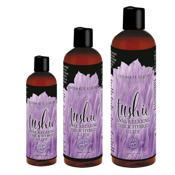 Size comparison view showing three amber bottles of Intimate Earth Tushie thick hybrid glide standing side by side in 60 ml (2 fl oz), 120 ml (4 fl oz), and 240 ml (8 fl oz) capacities.