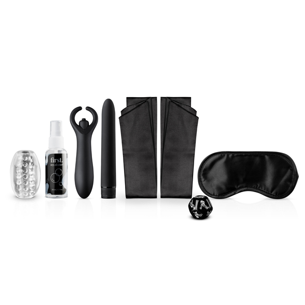 The contents of the LoveBoxxx First Together Starter Set arranged, including a clear masturbator sleeve, toy cleaner spray, two black vibrators (a couple's toy and a bullet), two black satin strips for handcuffs, a black satin blindfold, and a black sex dice.