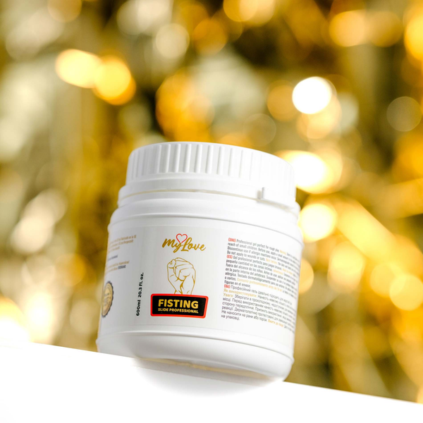 Front view of the 600 ml MyLove Fisting Slide Professional gel tub set against a warm, heavily blurred golden bokeh lighting background.