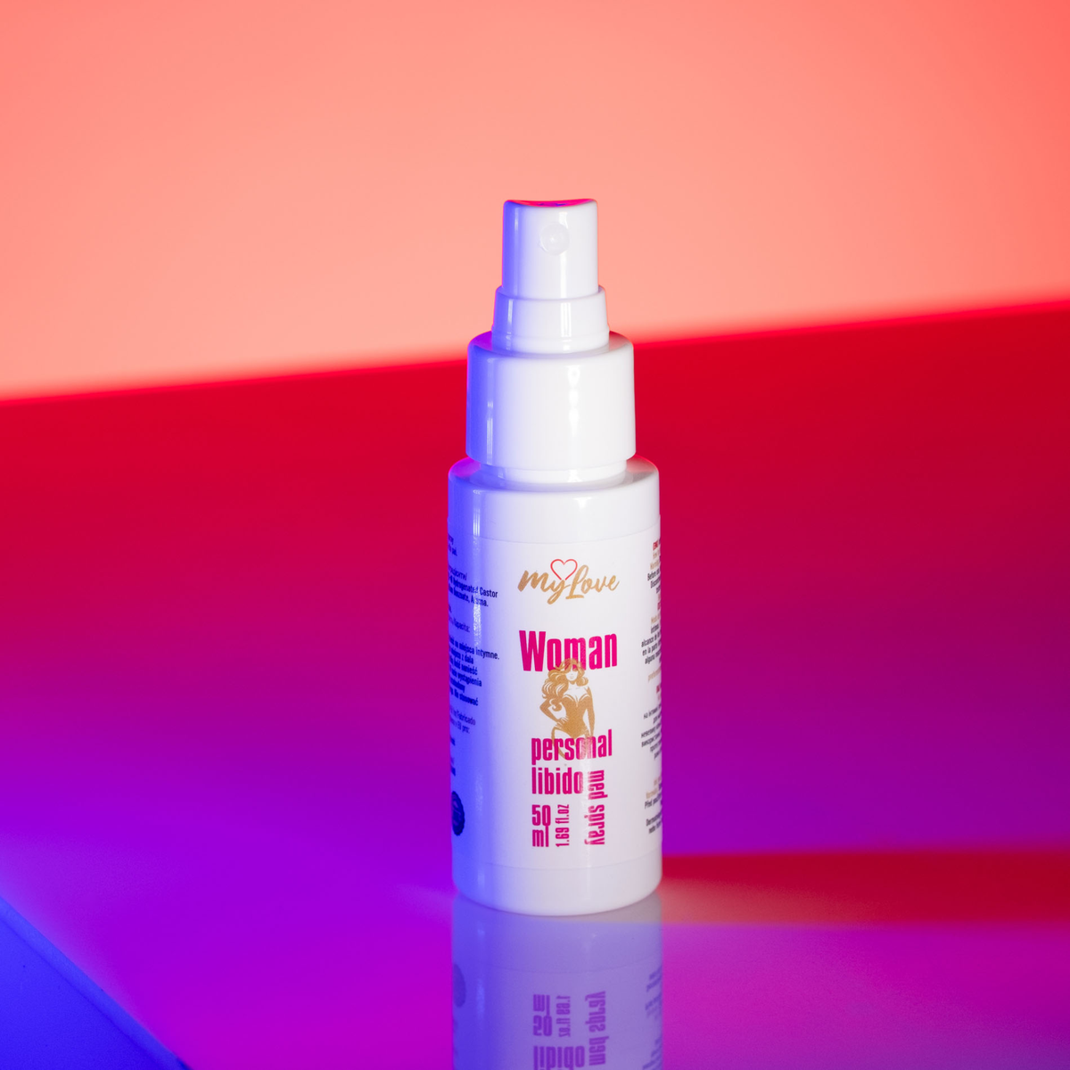 Front view of the 50 ml MyLove Woman Personal Libido Med Spray bottle illuminated under dynamic pink and blue studio lighting.