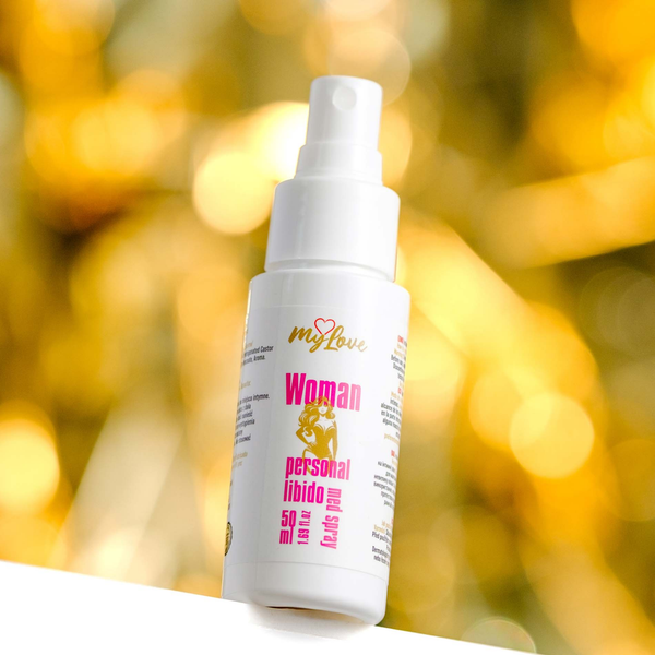 Front view of the 50 ml MyLove Woman Personal Libido Med Spray bottle set against a warm, heavily blurred golden bokeh lighting background.