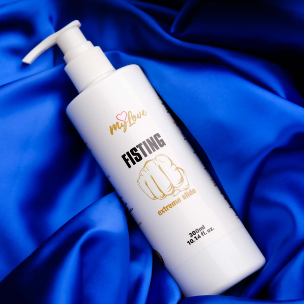 The 300 ml pump bottle of MyLove Fisting Extreme Slide gel rests at an angle on draped, deep royal blue satin fabric.