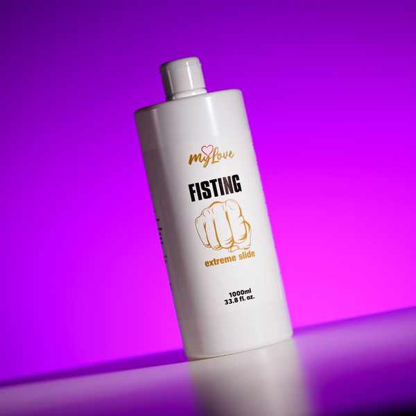 Front view of the large 1000 ml MyLove Fisting Extreme Slide bottle standing at an angle on a white surface against a bright purple backlit background.