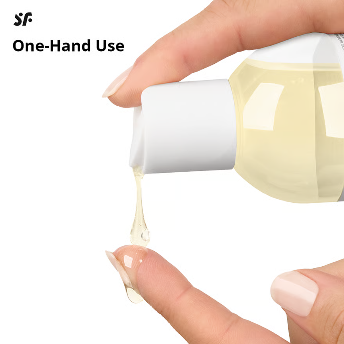 Close-up showing one-handed usage as golden massage oil is dispensed from the press cap onto a fingertip.