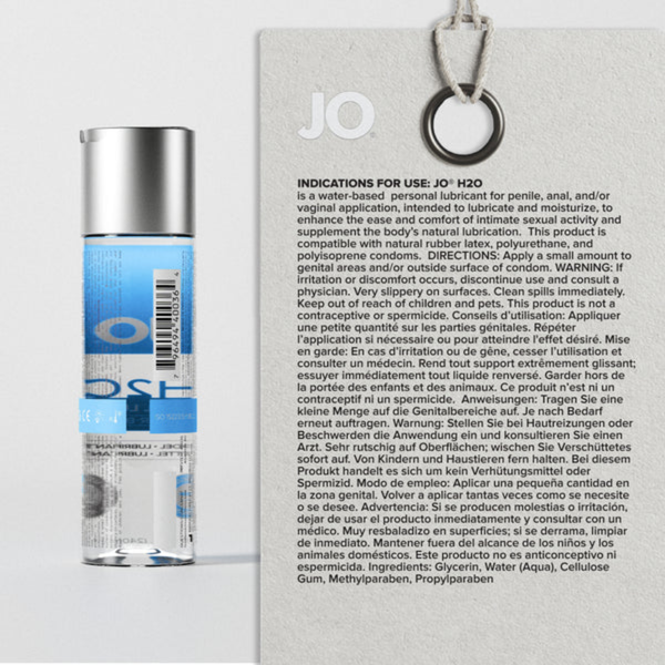 A black and white photograph of a happy couple smiling in bed. The red "JO" logo is displayed next to text introducing H2O Original as "the everyday essential" for solo, partner, or toy play.