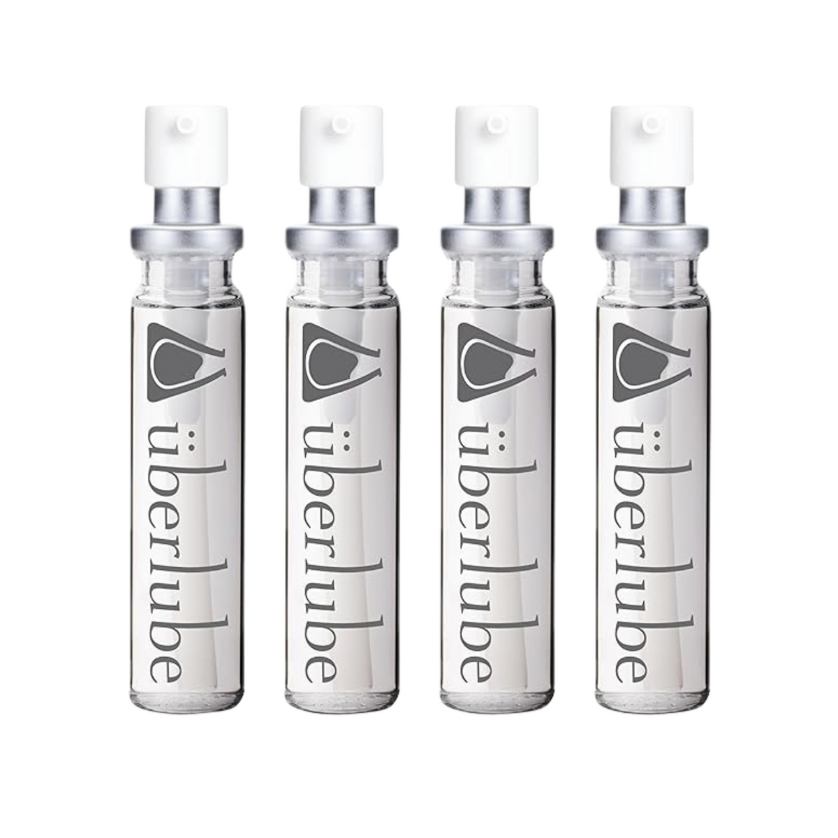 Four transparent glass spray bottles of Überlube lubricant, each with "überlube" and a stylized eye logo printed vertically, stand in a row. These travel-friendly WorldCondoms offerings provide discreet, on-the-go intimacy. Imagen principal del producto