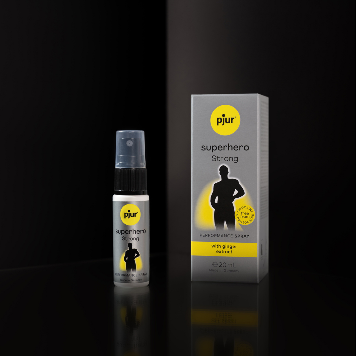 A gray box and spray bottle of Pjur Superhero Strong are shown against a dark background